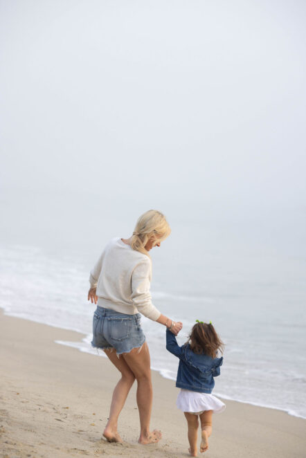 joanna holding daughters hand on the beach